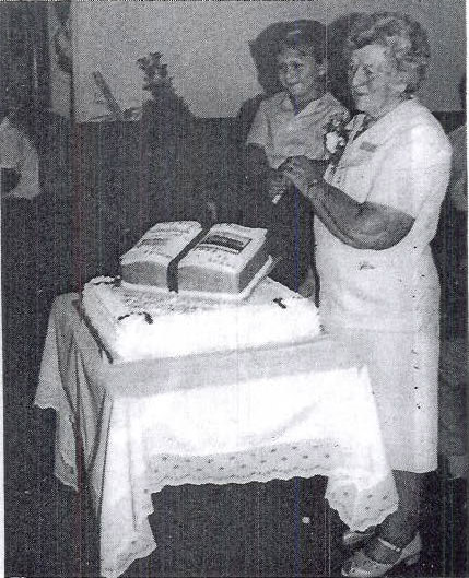 Mrs Eileen Ashton and John Brocket cutting the Cake