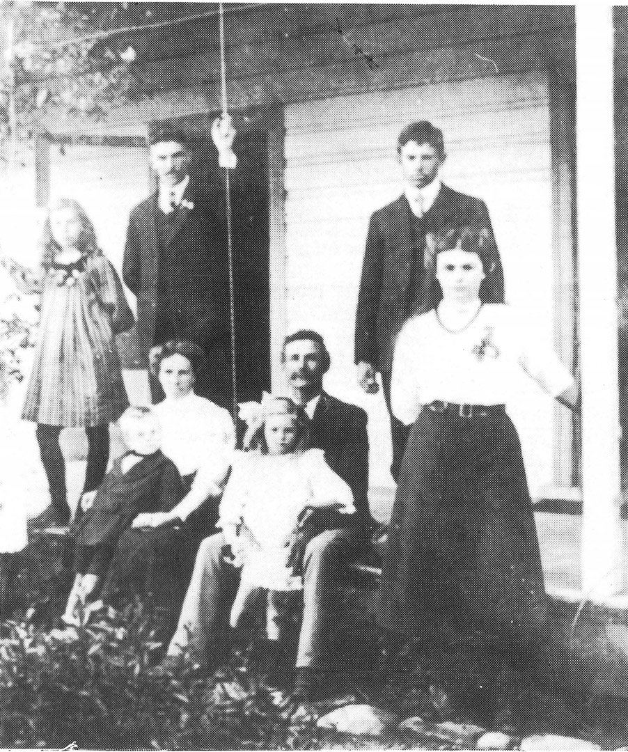 Daniel and Clara Tribe with some of their family on the porch of their homestead