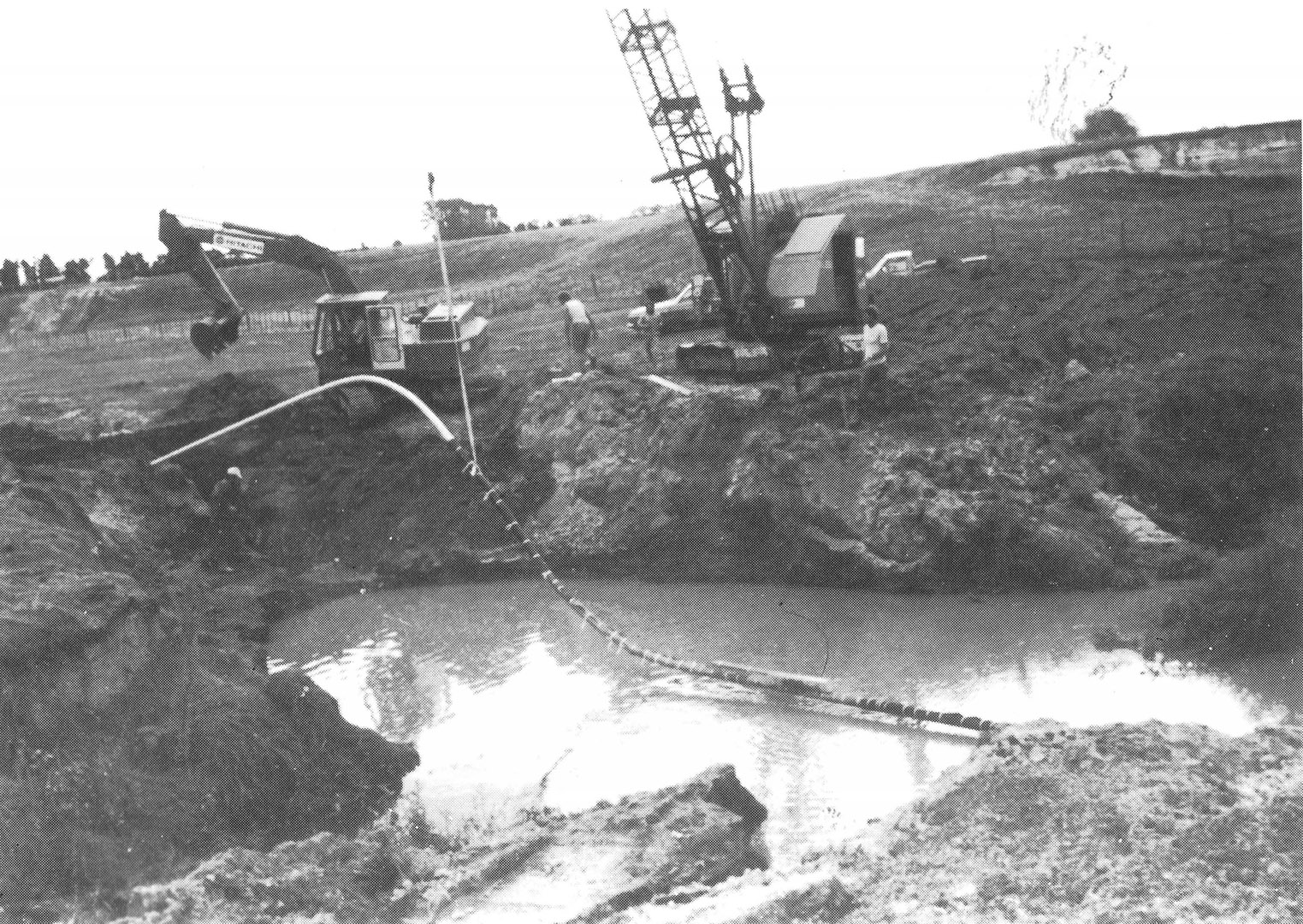 Laying the natural gas pipeline over the Waitakaruru Stream on Barry Geange's farm in 1982.
